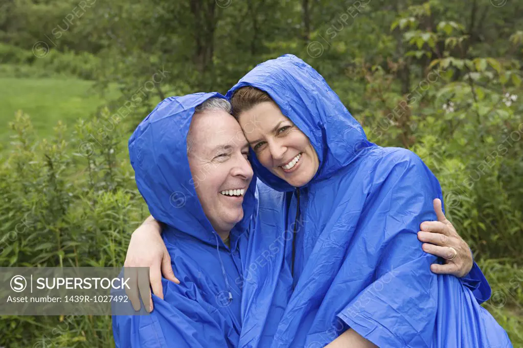 Mature couple wearing raincoats