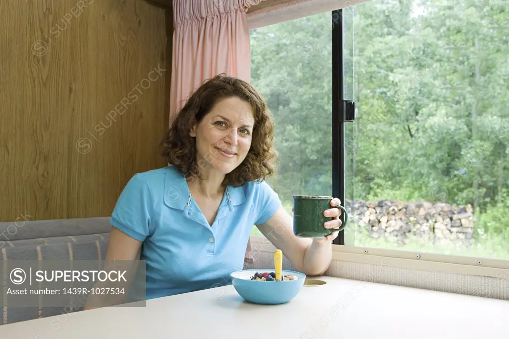 Woman having breakfast in a caravan