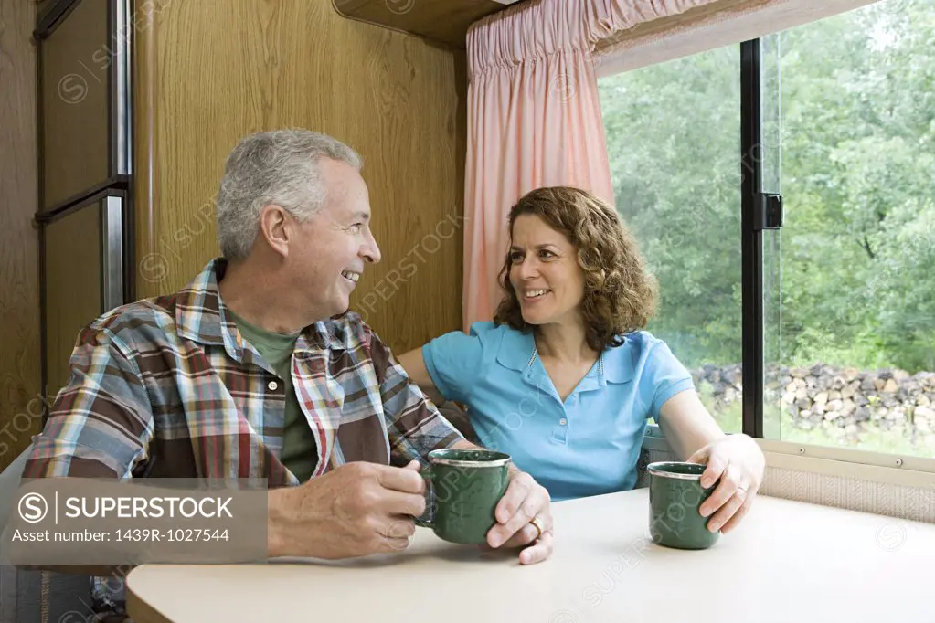 Couple drinking coffee in a caravan
