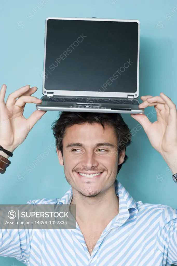 Man with laptop on his head