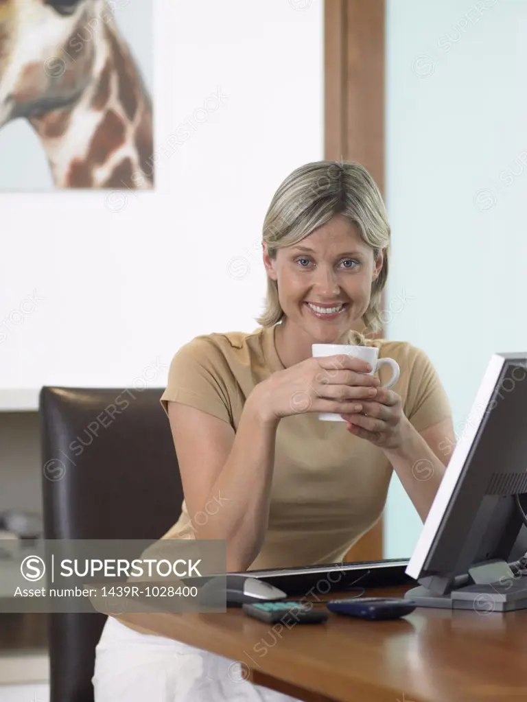 Woman having coffee at computer
