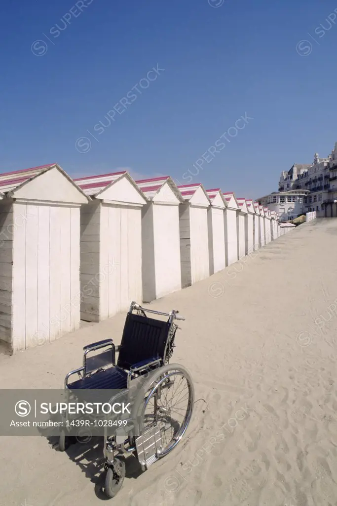 Wheelchair by row of beach huts
