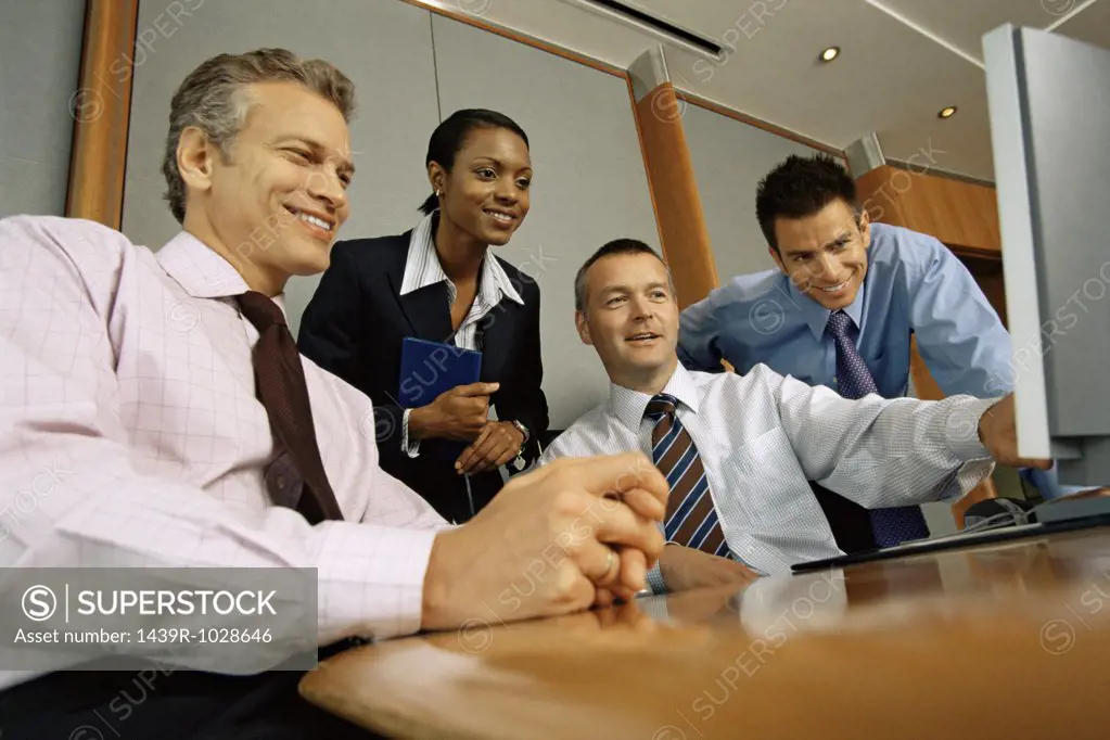 Businesspeople looking at computer monitor