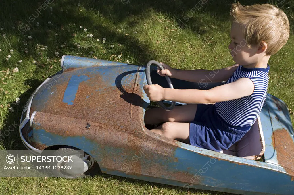 Boy in an old toy car