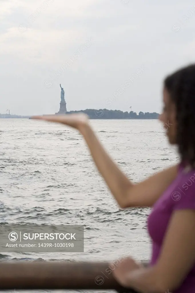 Woman pretending to hold statue of liberty