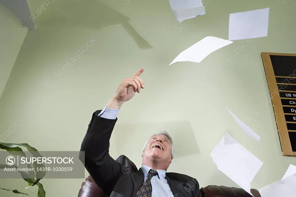 Businessman throwing paper in the air