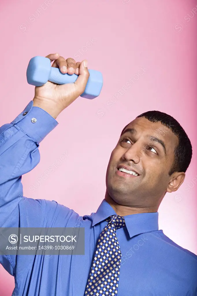 Man struggling to lift a dumbbell