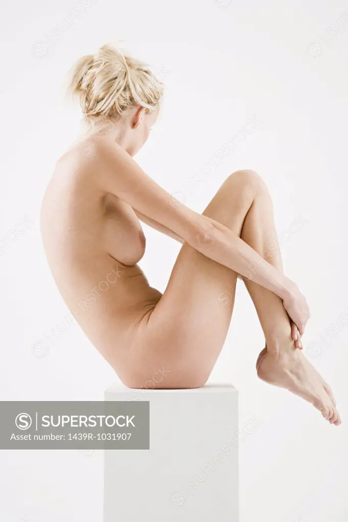 Nude woman sitting on a box