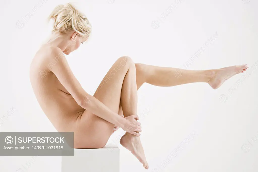 Nude woman sitting on a box
