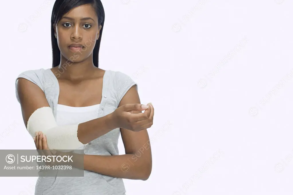 Woman holding bandaged arm