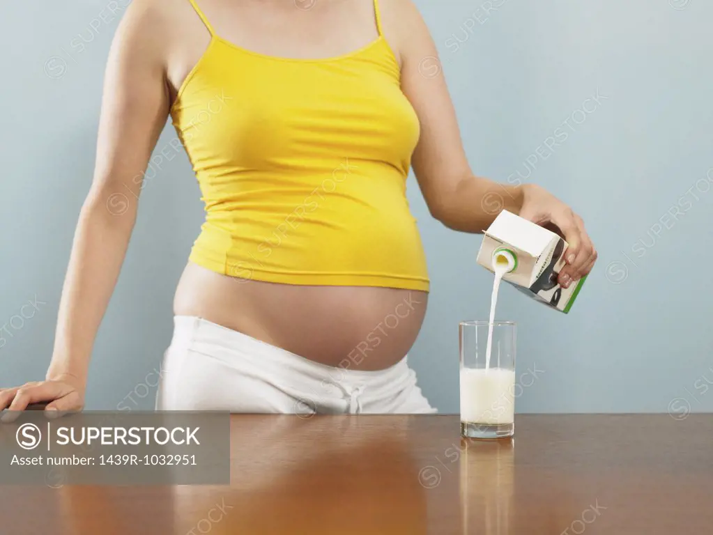 Pregnant woman pouring milk