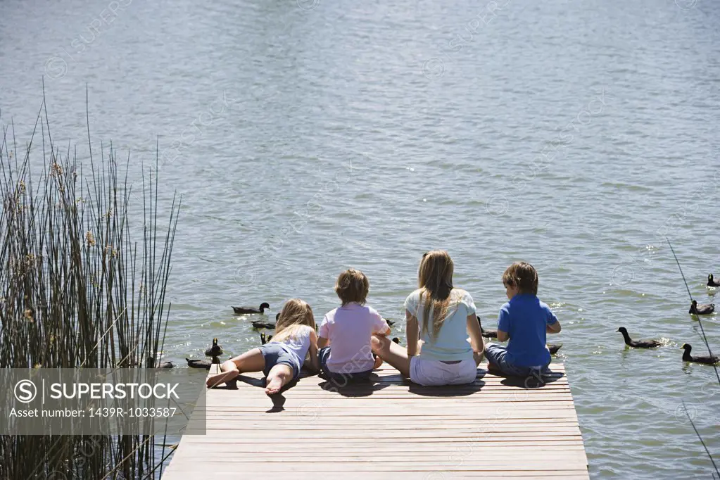 Children feeding ducks on a lake