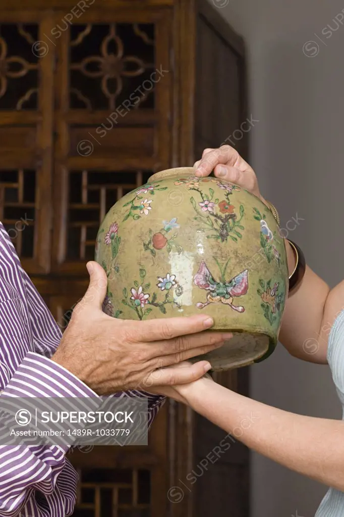 People holding a vase