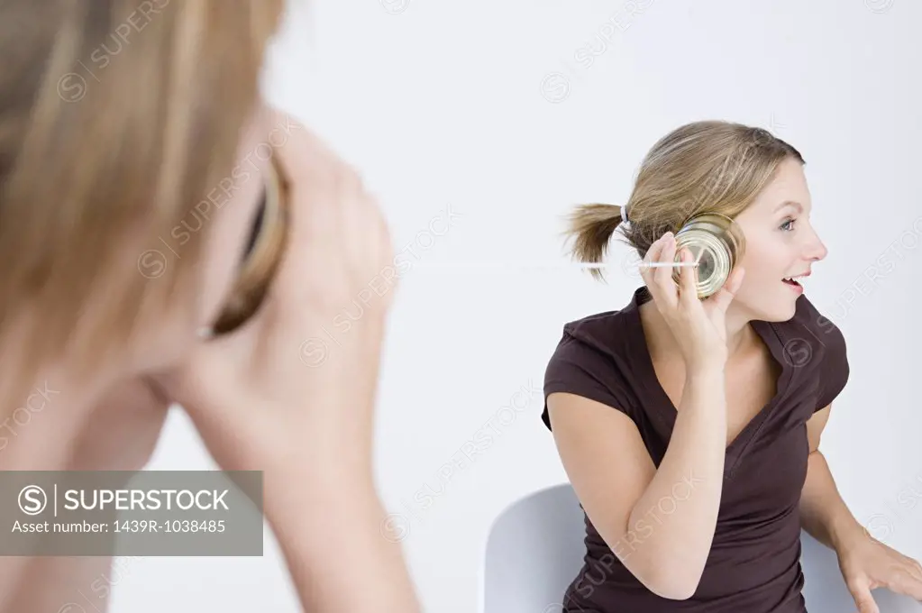 Women using tin can telephone