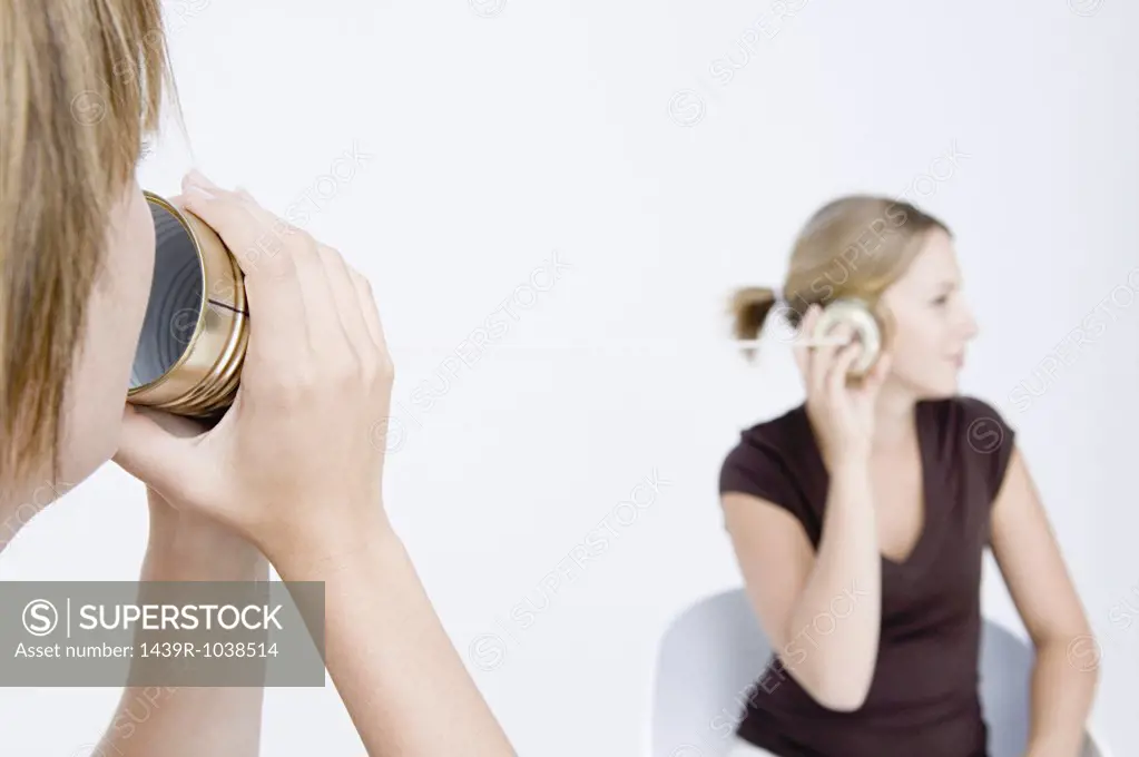 Women using tin can telephone