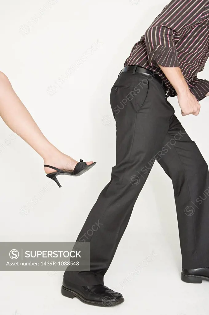 Woman about to kick a man