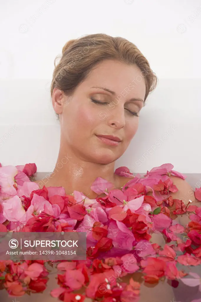 Woman in a bath with petals