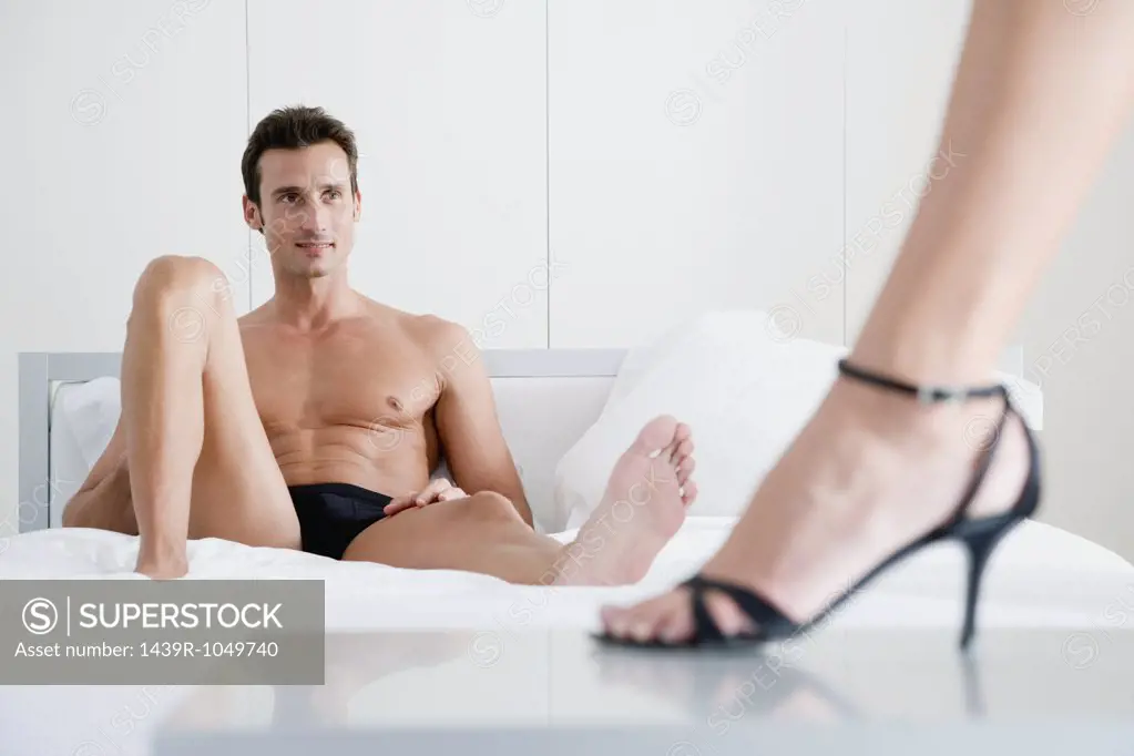 Man on bed and woman in high heels