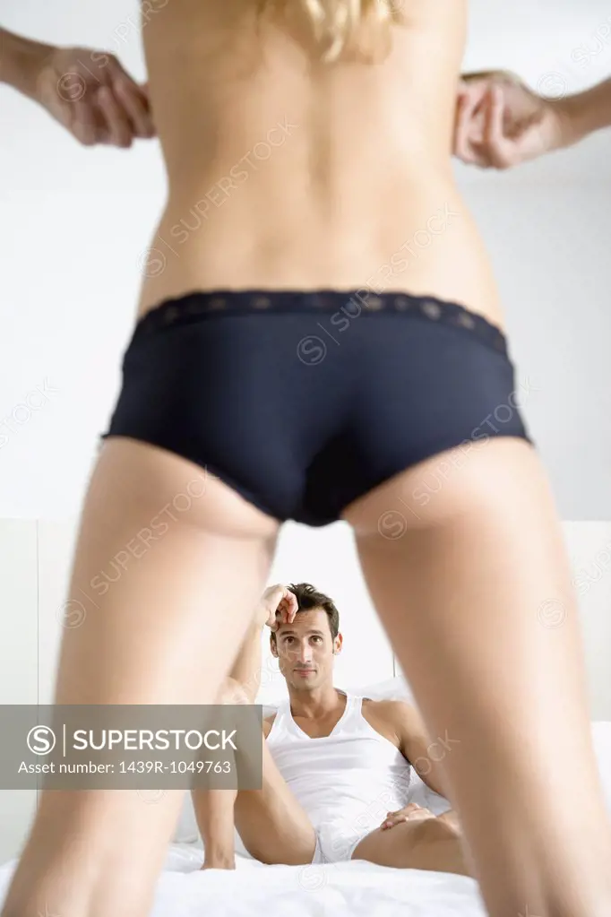 Man watching woman undress