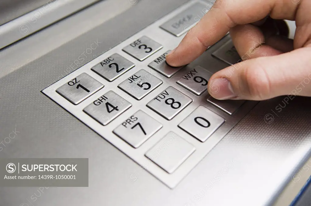 Person pressing cash machine keypad