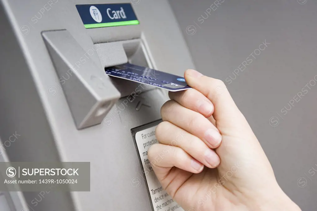 Person puttting card into cash machine