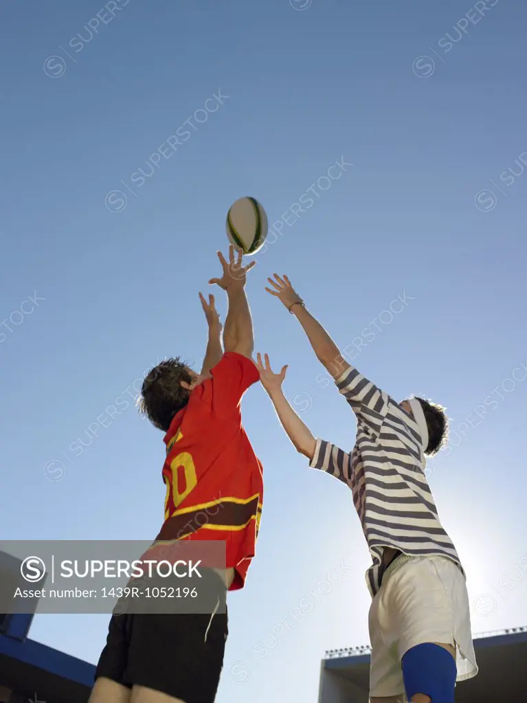 Rugby players reaching for ball