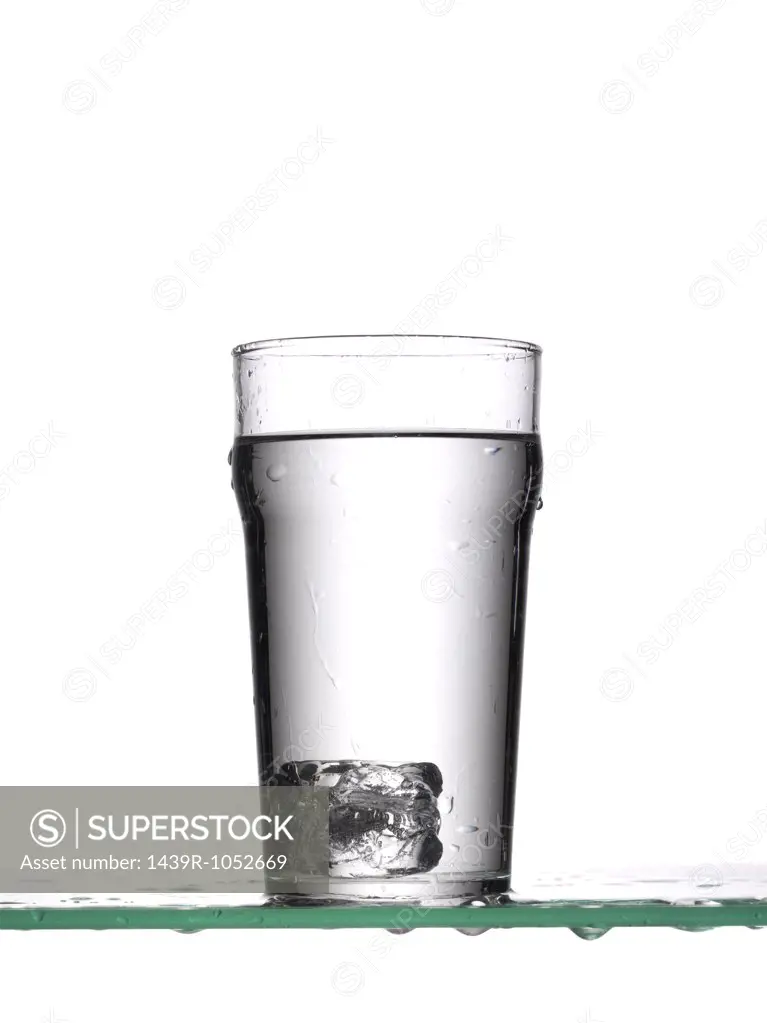 Ice cube in glass of water