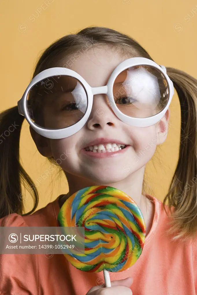 Girl with lollipop and big sunglasses