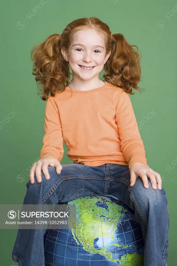 Girl sitting on inflatable globe
