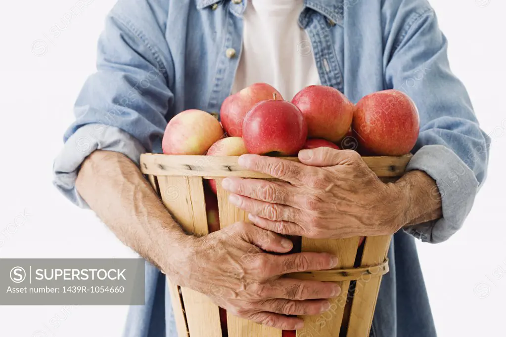 Man holding basket of apples