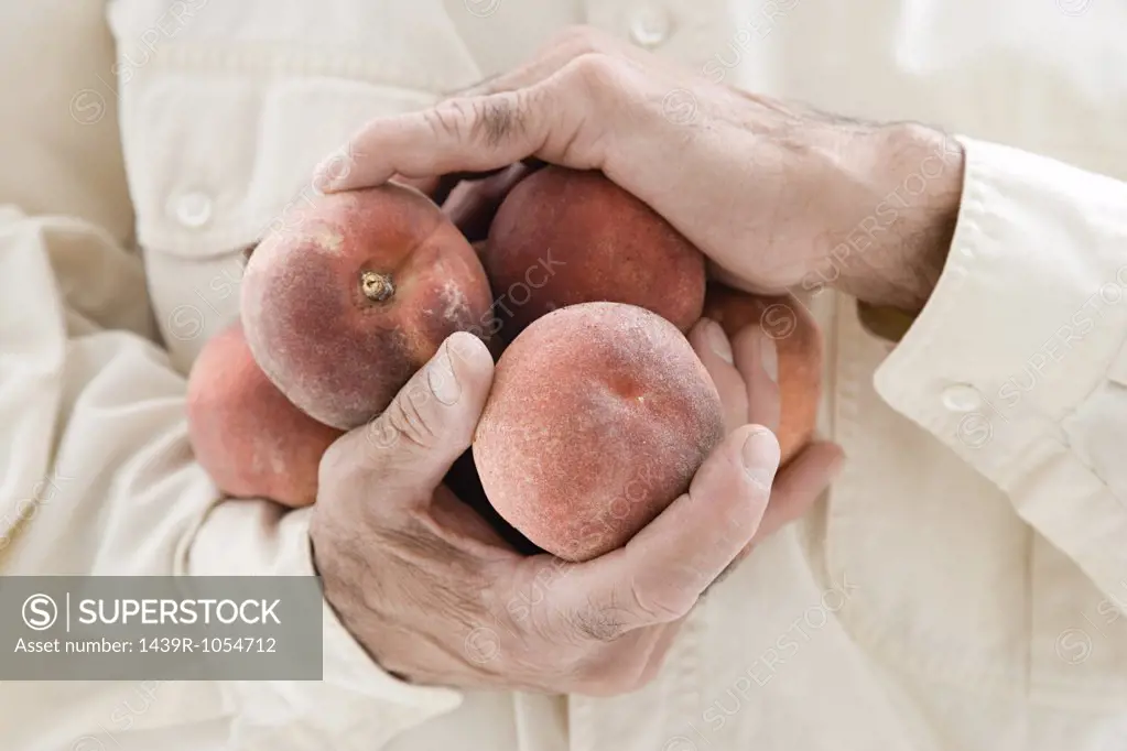 Man holding peaches