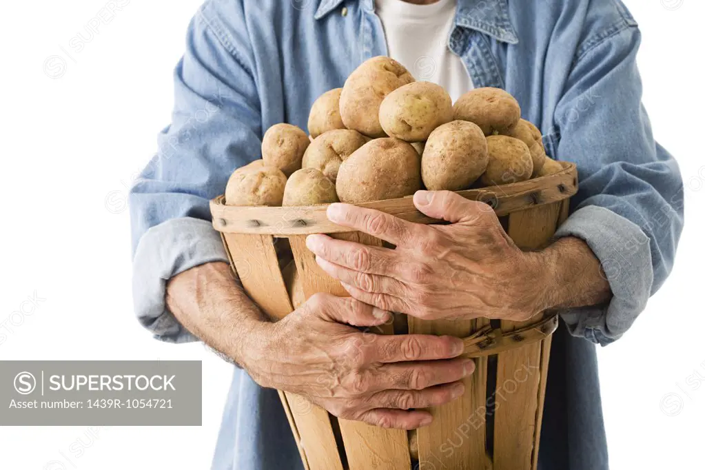 Man holding basket of potatoes