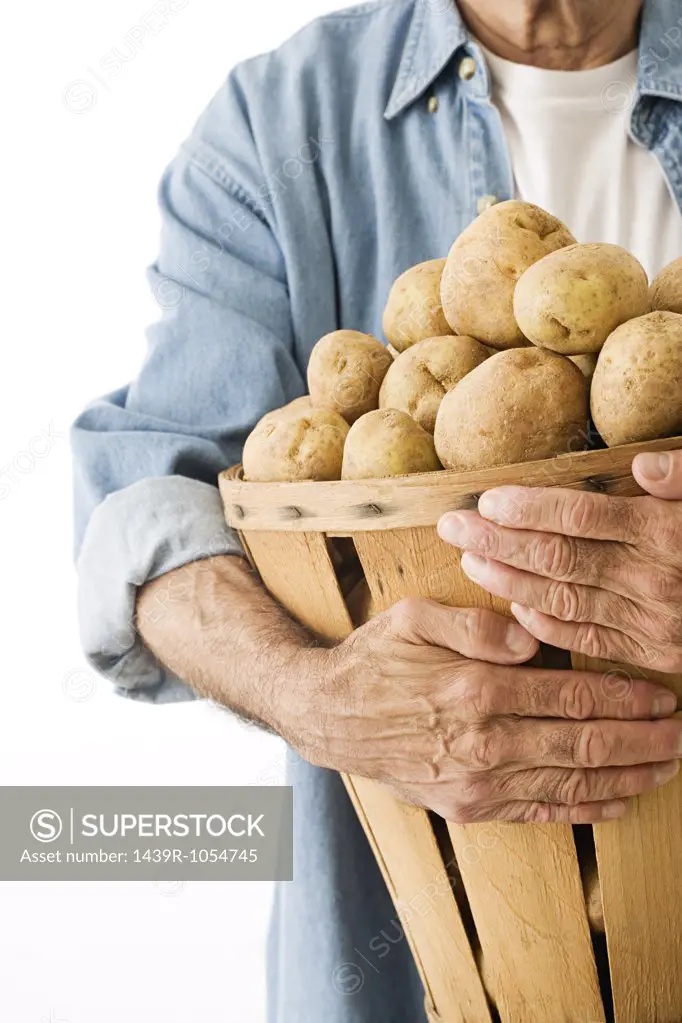 Man holding basket of potatoes