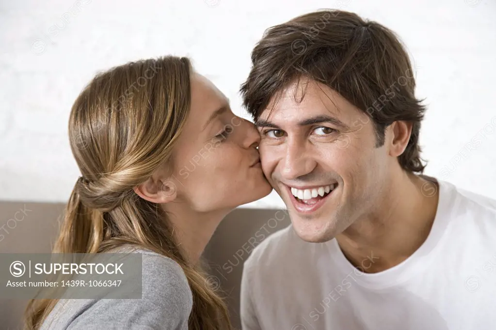 Woman kissing man on the cheek