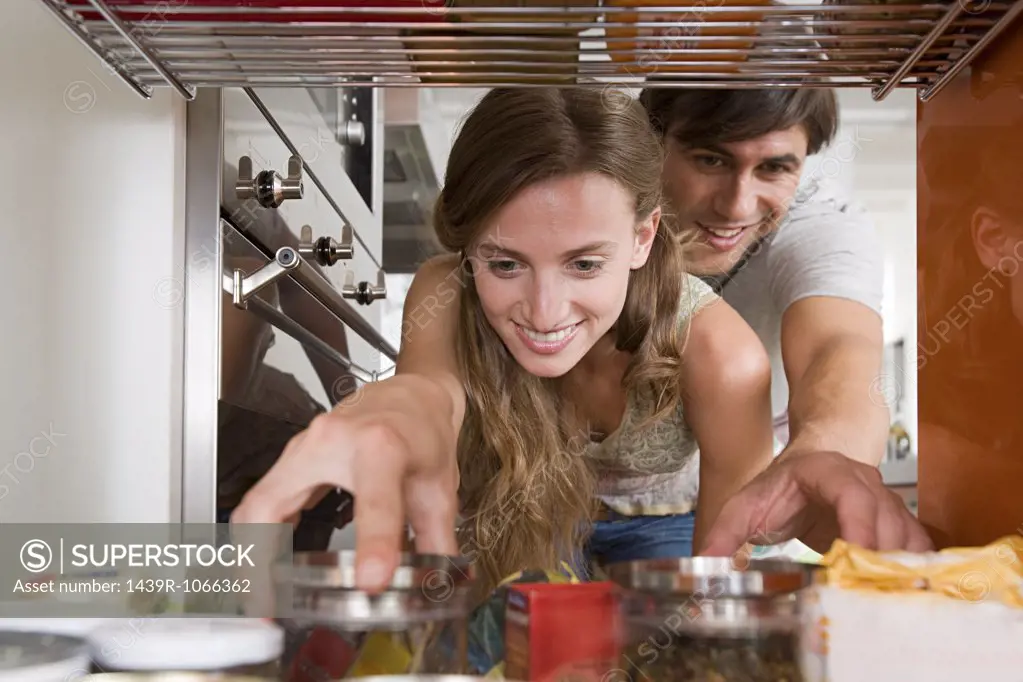 A couple reaching for jars of food