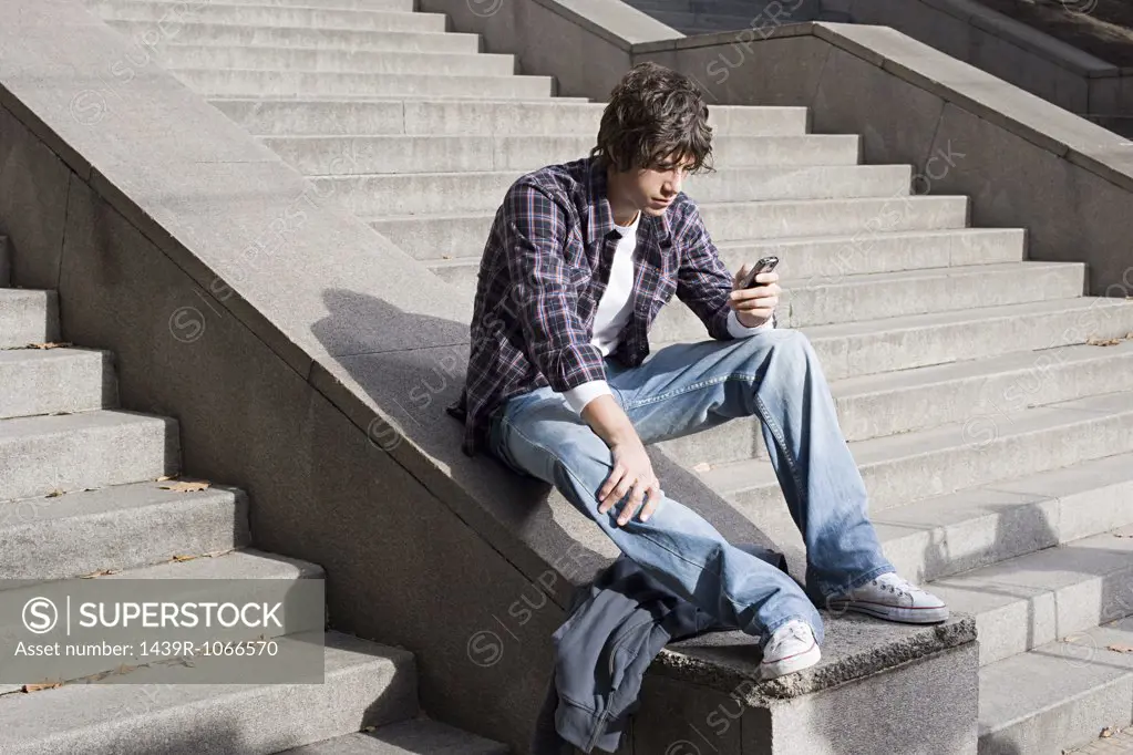 Boy text messaging on stairway