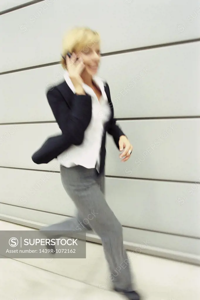 Running woman using a cellular telephone