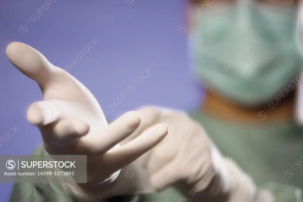 Surgeon putting on gloves