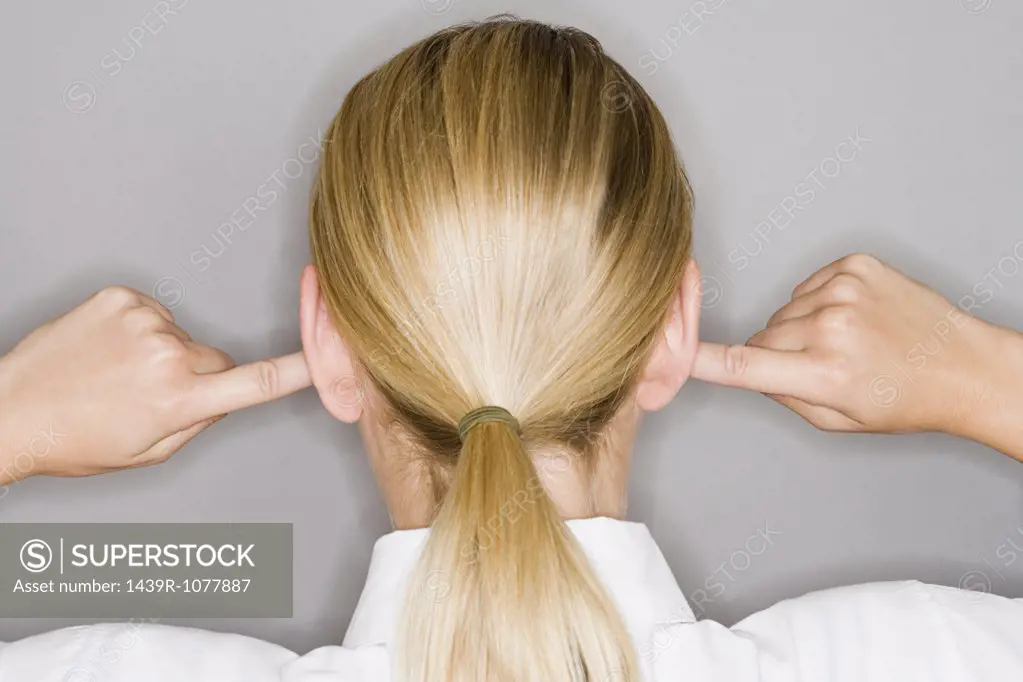 A woman with her fingers in her ear