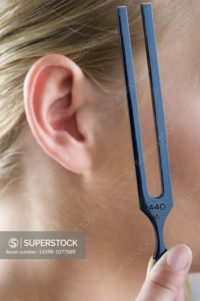 A woman holding a tuning fork