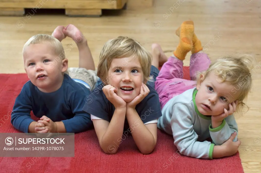 Three children lying on the floor
