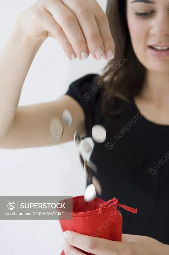 Woman dropping coins into purse