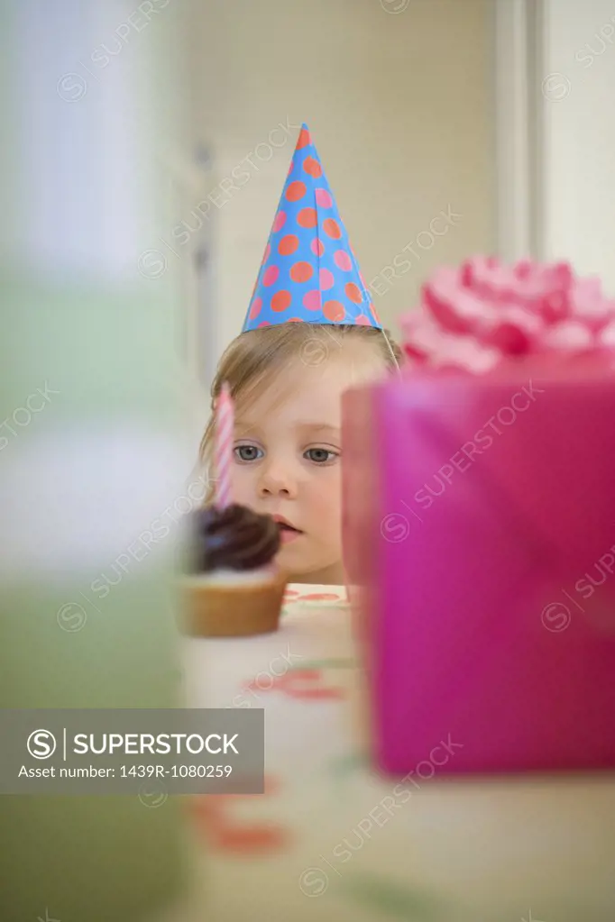 Little girl looking at cake