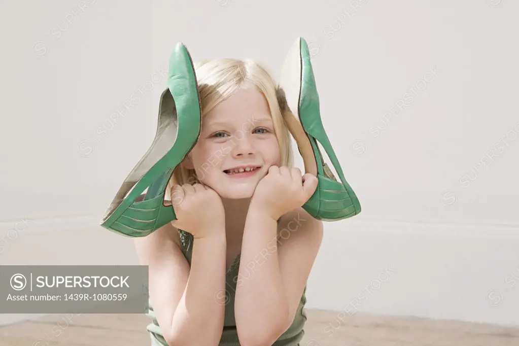 Girl holding a large pair of high heeled shoes