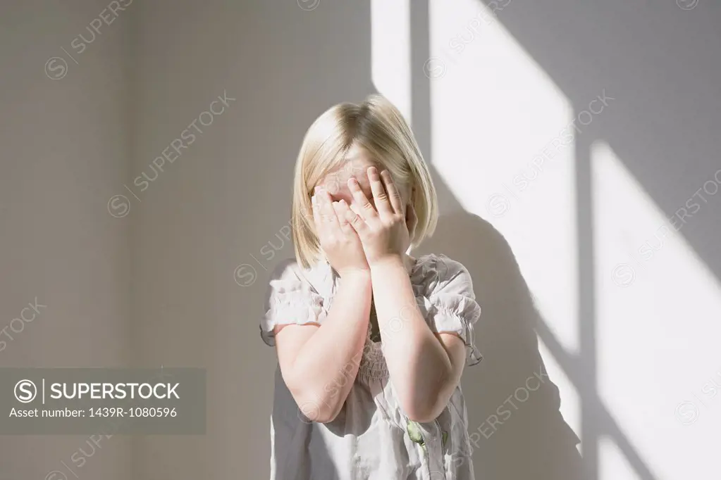 Girl covering her face her hands