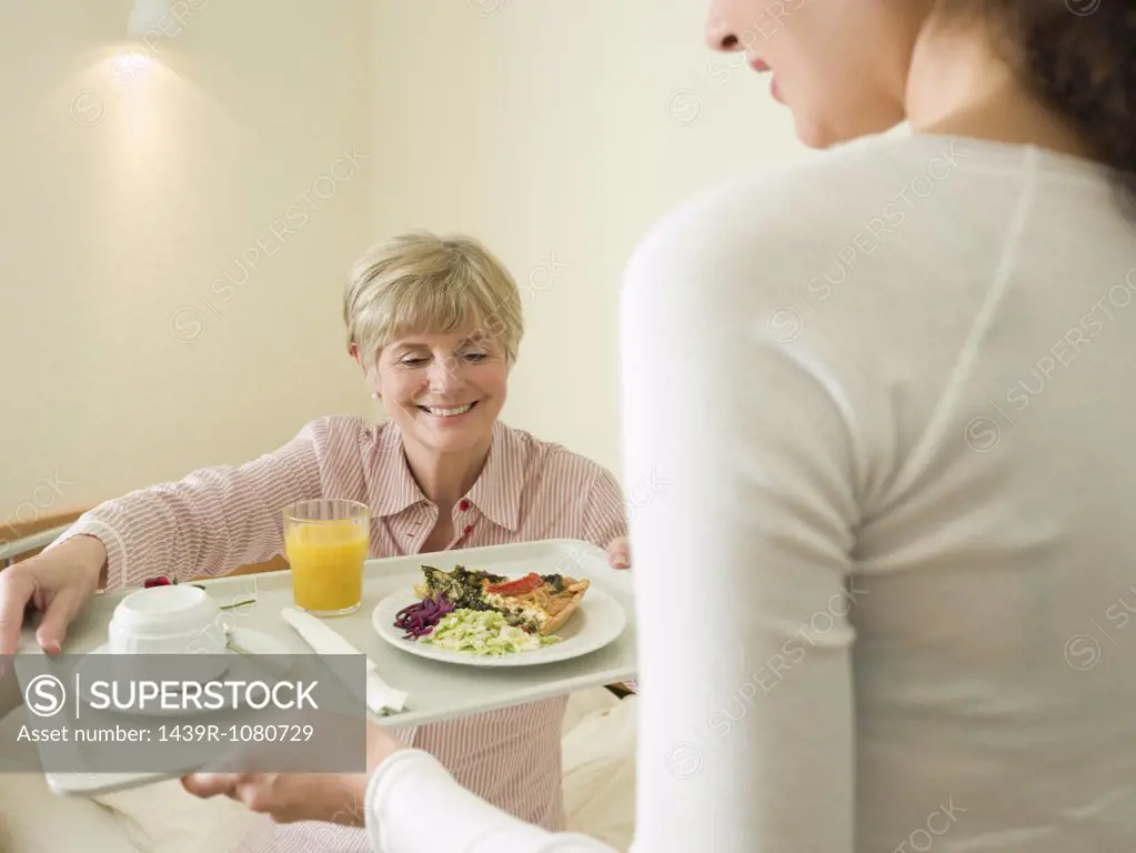 Woman getting lunch served in bed