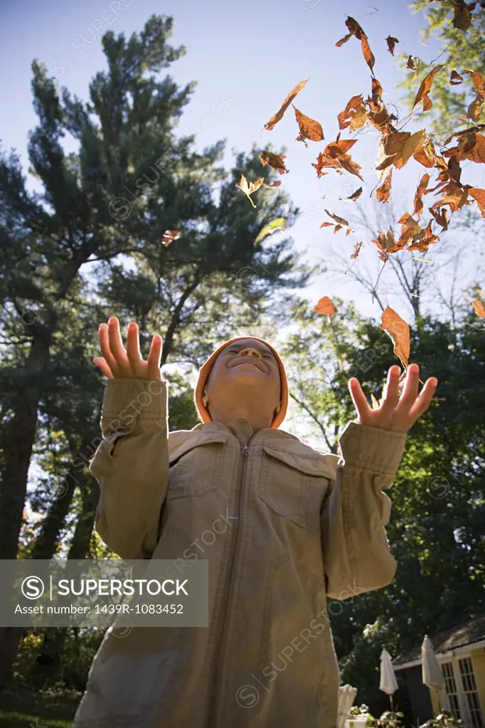 Boy throwing leaves