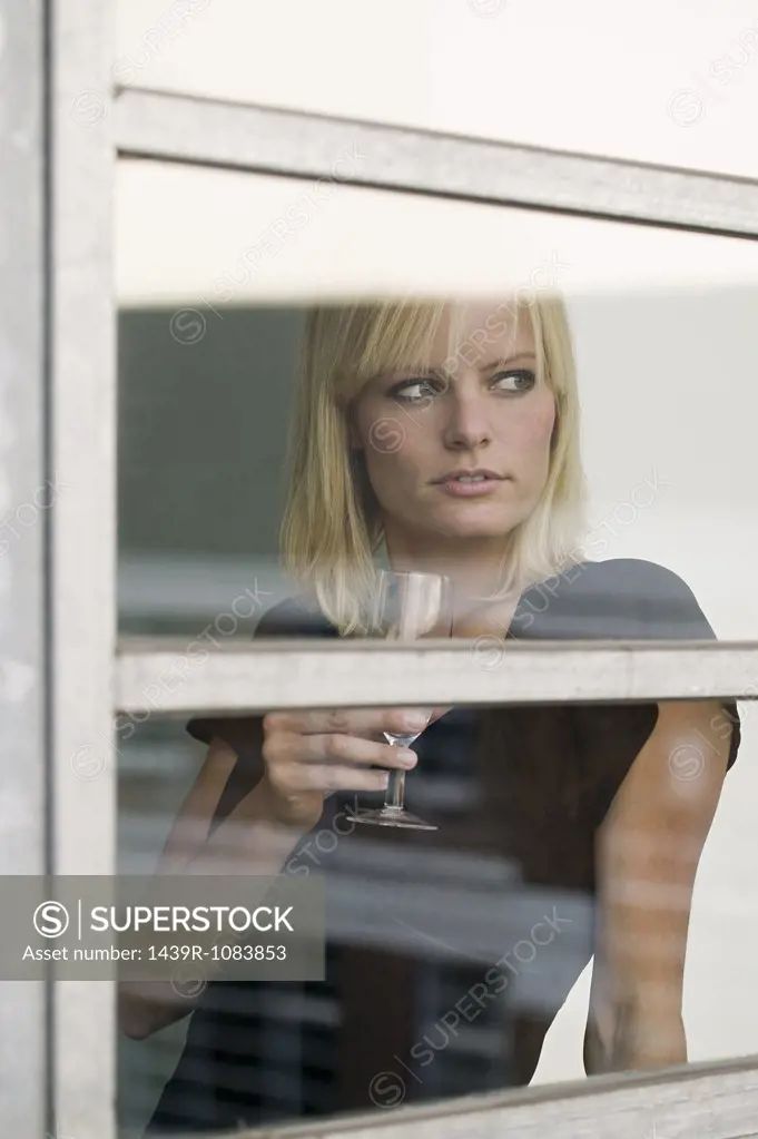 Woman by window with wine glass