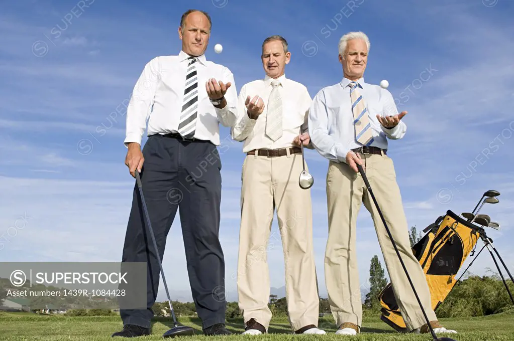 businessmen throwing golf balls