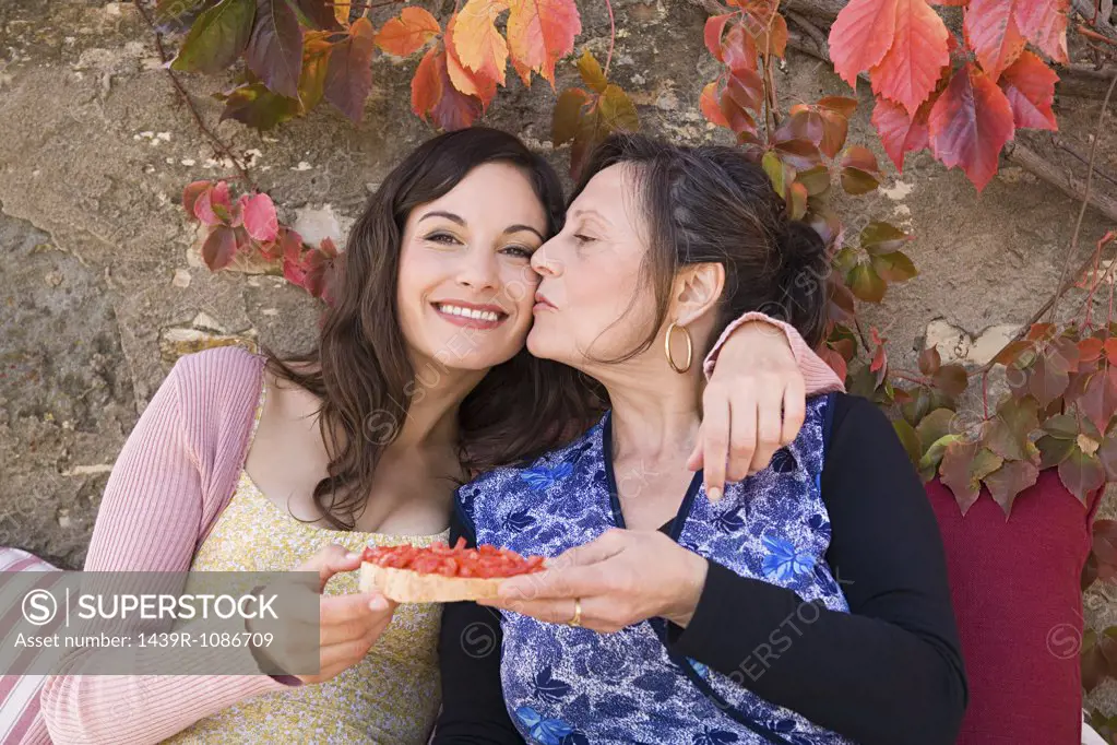 Mother and daughter holding a slice of bruschetta